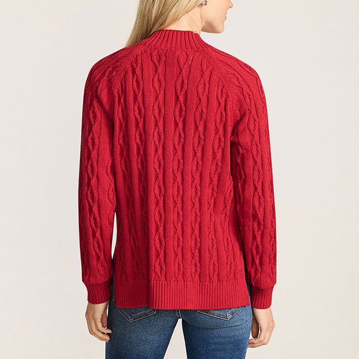 Woman wearing a red cable knit sweater on a light beige background