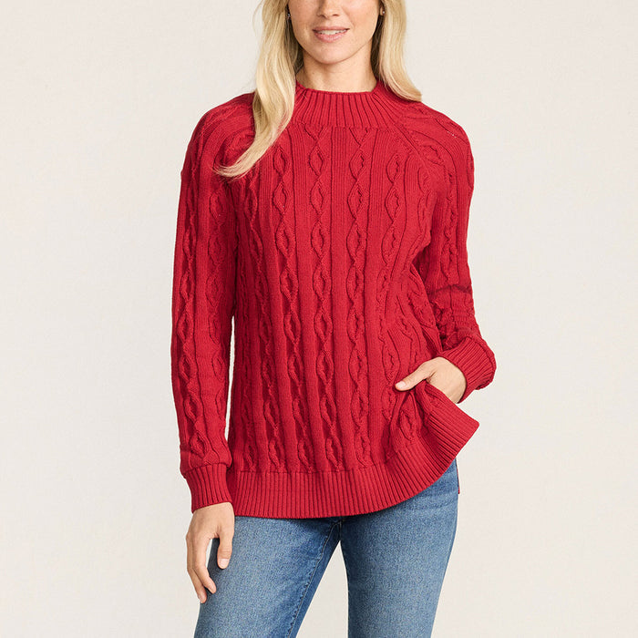 Woman wearing a red cable knit sweater on a light beige background