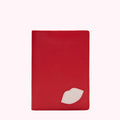 Red leather passport holder with a small off-white lip design.