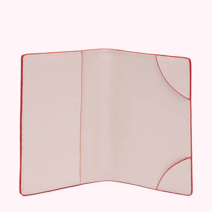 Red passport holder with beige interior open to show empty card slots.
