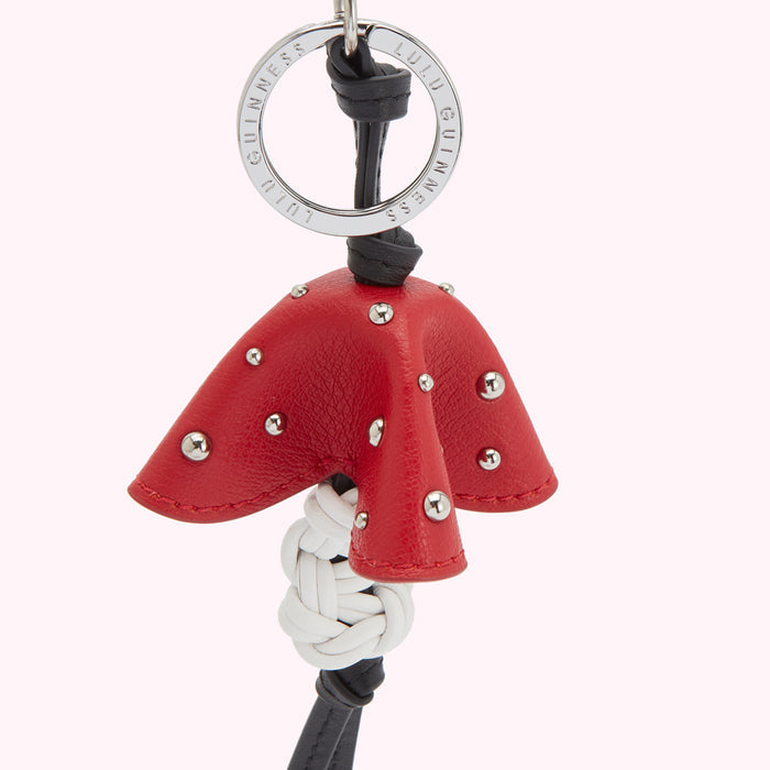 Red leather Lulu Guinness keyring in the shape of a mushroom with a white woven knot detail.