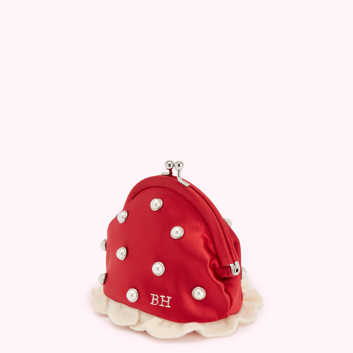 Red satin coin purse with pearl accents and embroidered initials "LG" on a cream ruffled trim.