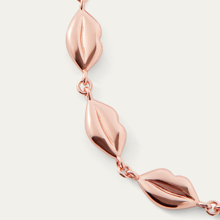 Rose gold lip chain bracelet on a light gray background