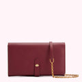 Burgundy leather wallet with gold chain strap and lip-shaped detail.