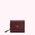 A burgundy leather wallet with a gold lip logo.