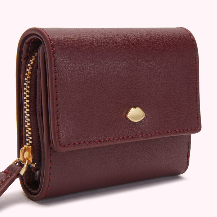 Burgundy leather wallet with gold zipper and lip-shaped clasp.