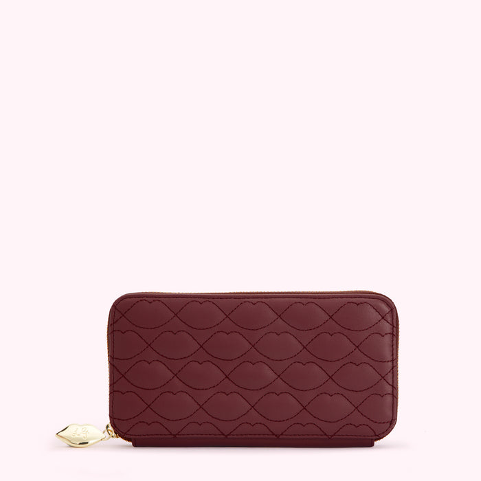 Burgundy quilted zip-around wallet with lip pattern.