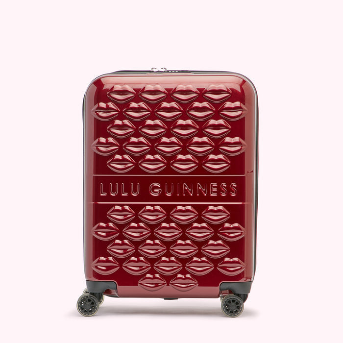 Red Lulu Guinness suitcase covered in embossed lips.