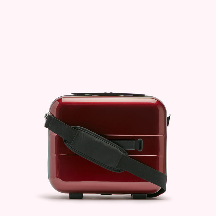 Red carry-on suitcase with black shoulder strap, against a white background.