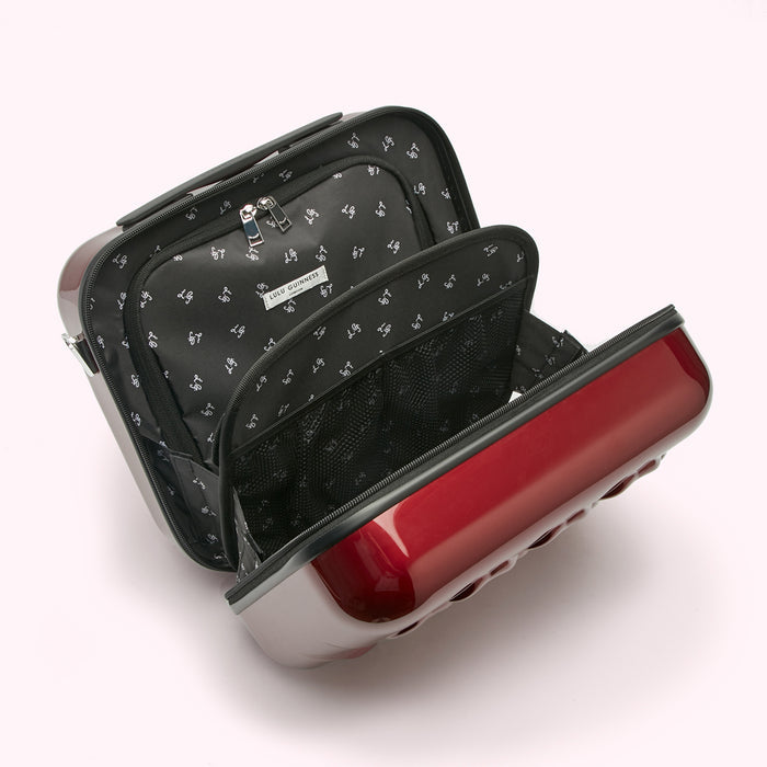 Open red Lulu Guinness travel case showing interior compartments and black patterned lining.