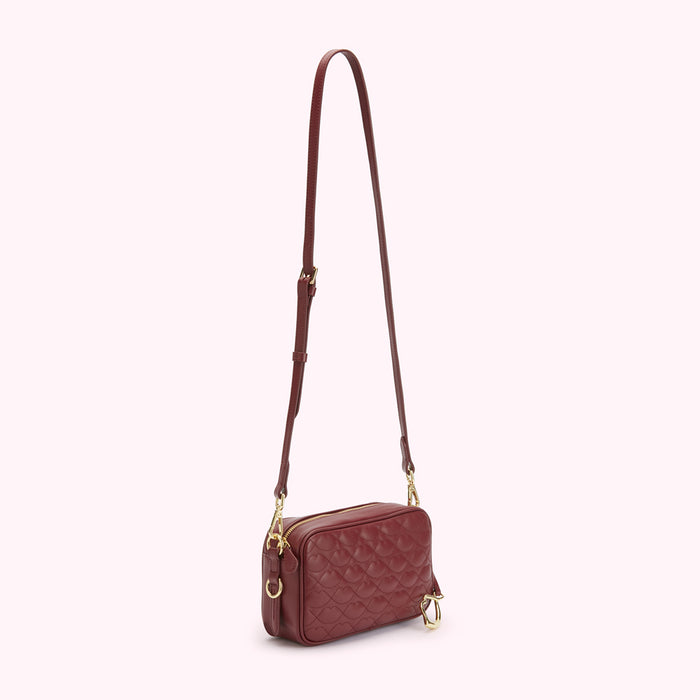Burgundy quilted crossbody bag with gold hardware.