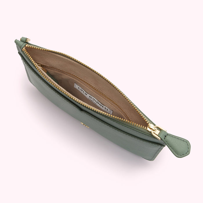 Sage green Lulu Guinness zip-around pouch open to reveal beige interior compartments and gold-toned hardware.