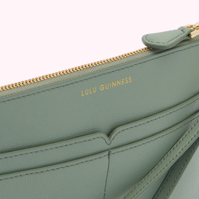 Close-up of a sage green Lulu Guinness zip-around purse with gold zipper and logo.