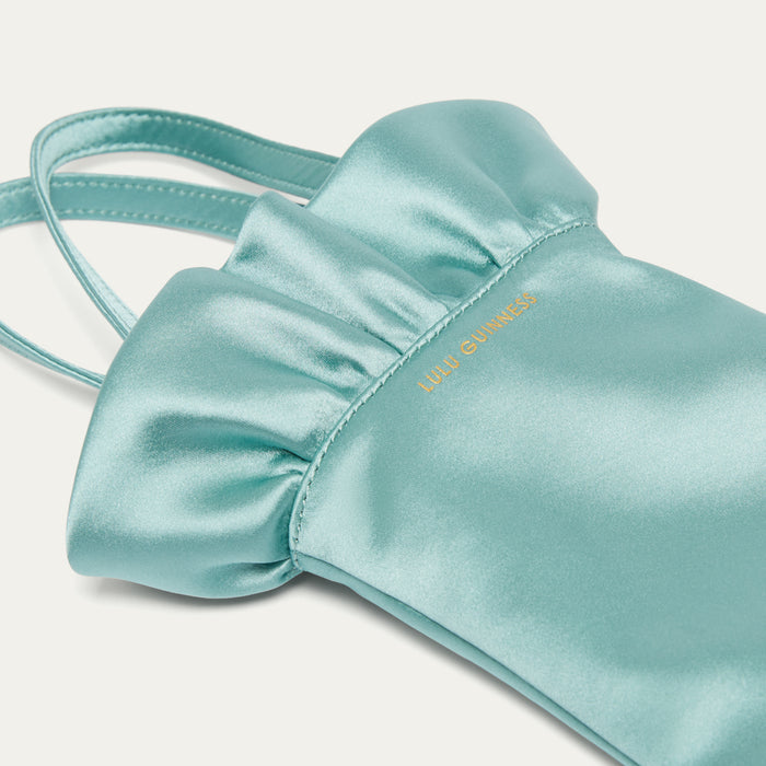 Light blue satin hand-shaped bag with 'Lulu Guinness' branding on a light gray background