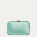 Mint green satin clutch bag with a gold lip-shaped clasp on a light beige background