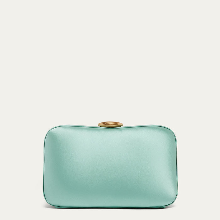 Mint green satin clutch bag with a gold lip-shaped clasp on a light beige background