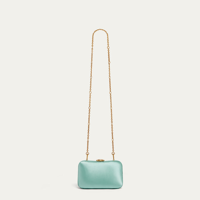 Mint green satin clutch bag with a gold lip-shaped clasp and chain on a white background
