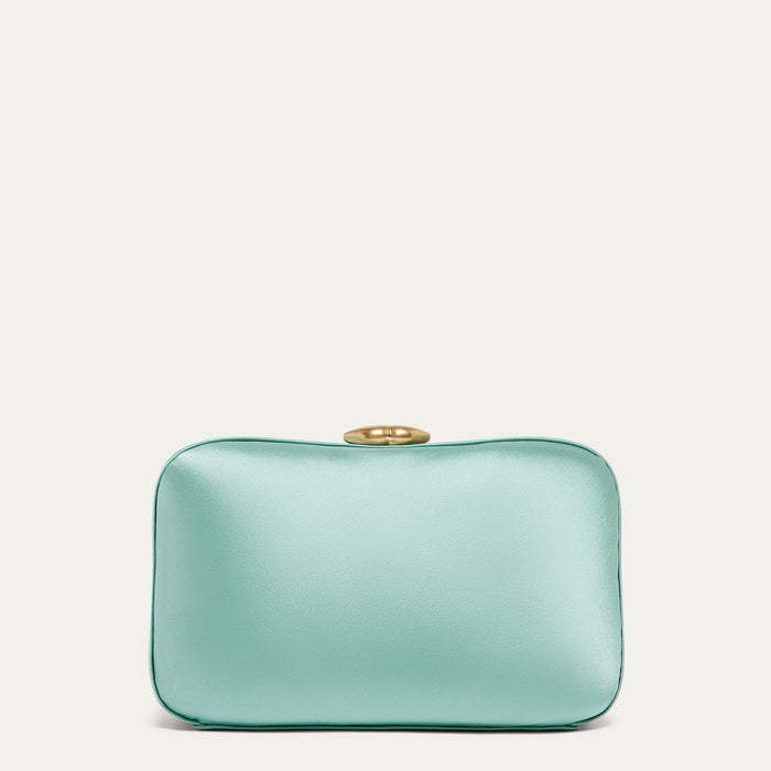 Mint green satin clutch bag with a gold lip-shaped clasp on a light beige background