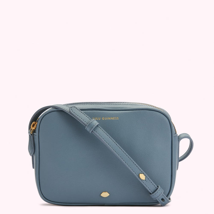 A dusty blue Lulu Guinness crossbody bag with gold hardware.