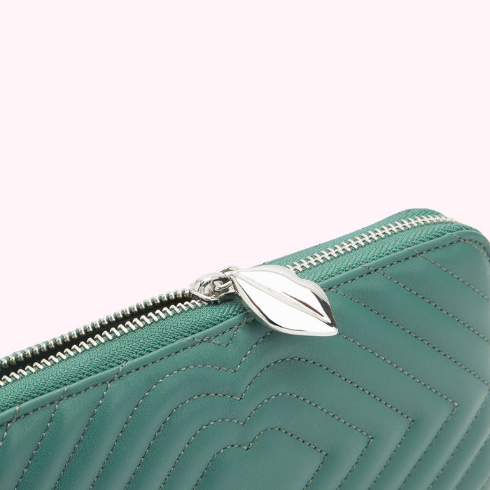 Close-up of a teal quilted leather zip wallet with a silver leaf-shaped zipper pull.