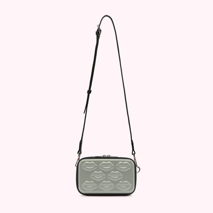 Sage green crossbody bag with black strap and lip-shaped embellishments.
