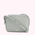 Light teal Lulu Guinness crossbody bag with gold zipper and logo.