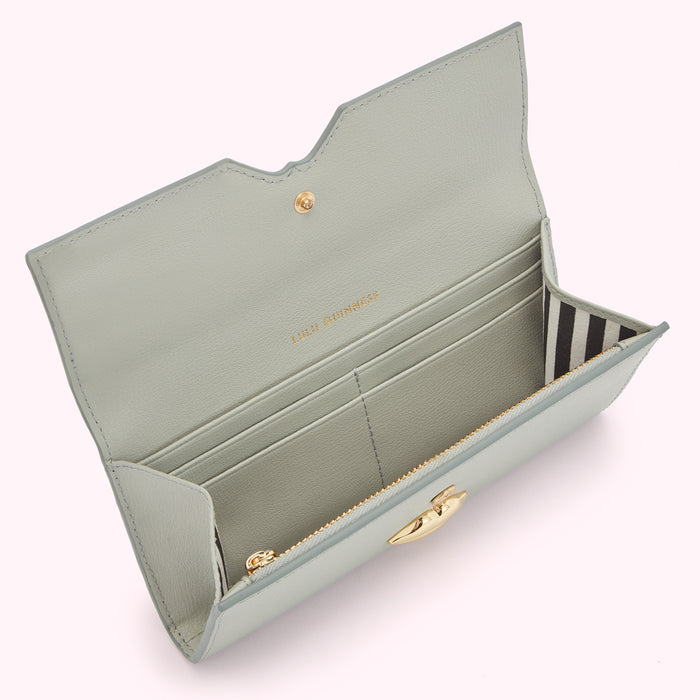 Open light green leather wallet with gold clasp and black and white striped interior.