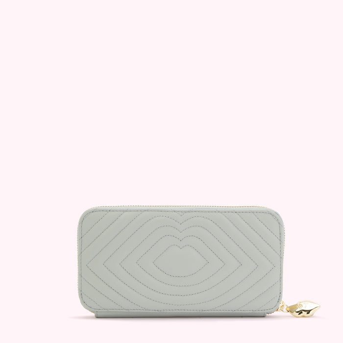 Light sage green quilted zip-around wallet with gold zipper and charm.
