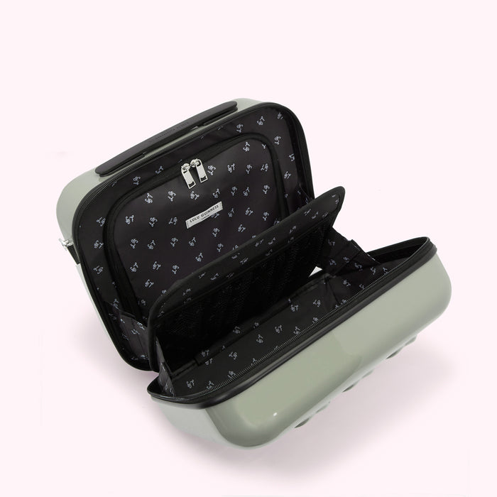 Open sage green Lulu Guinness suitcase with black interior lining and compartments.