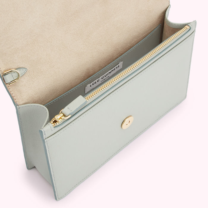 Open light-blue Lulu Guinness crossbody bag with gold zipper and clasp.