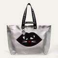 Silver tote bag with black cat design and Lulu Guinness handle on a white background