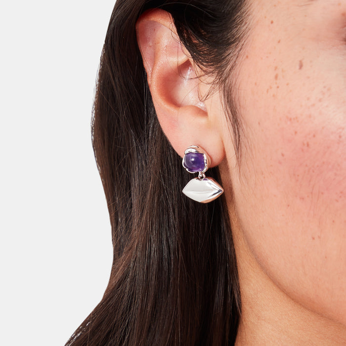Silver lip-shaped earrings with purple amethyst stones.