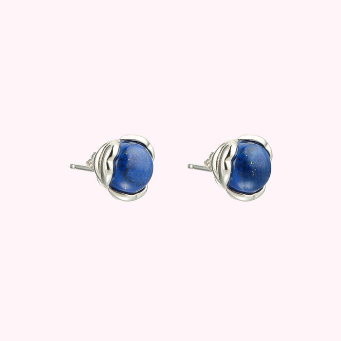 Pair of lapis lazuli stud earrings with silver settings against a white background.