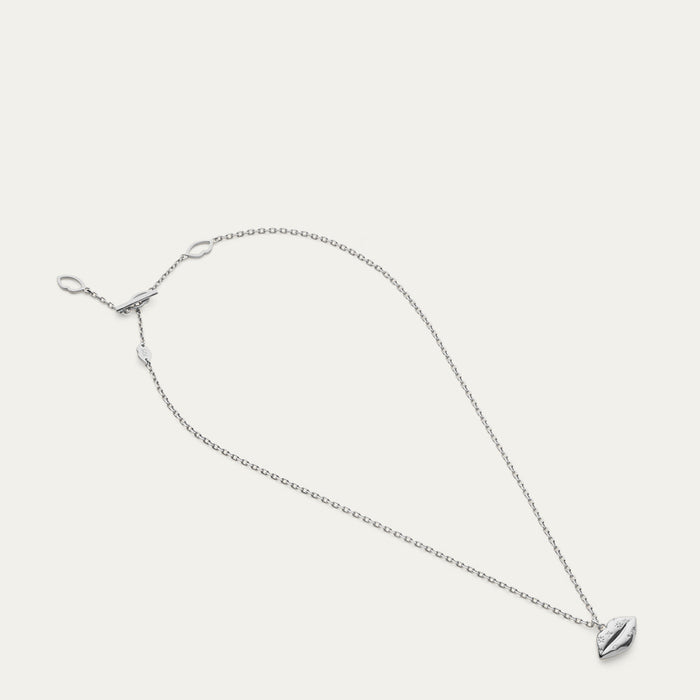 Silver necklace with a small lip shaped pendant with a crystal design on a light gray background