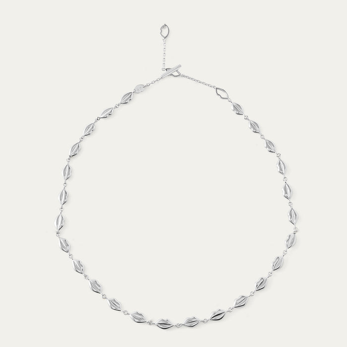 Silver lip chain necklace on a light gray background