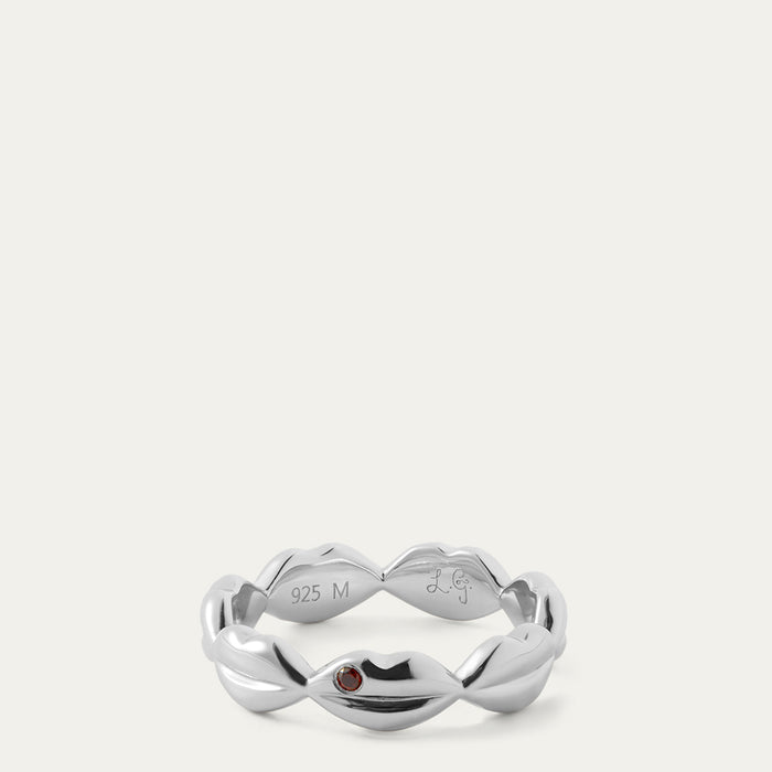 Silver ring with a red gemstone on a white background