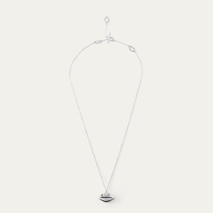 Silver and ruby necklace with a lip-shaped pendant on a white background