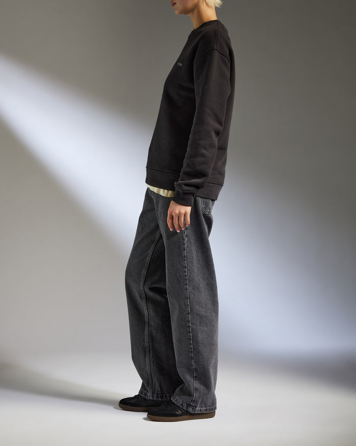 a person standing in a black sweatshirt and jeans