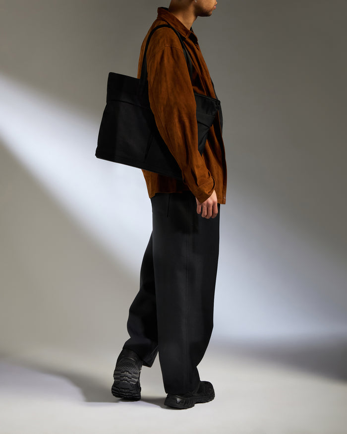 a man in a brown shirt and black pants
