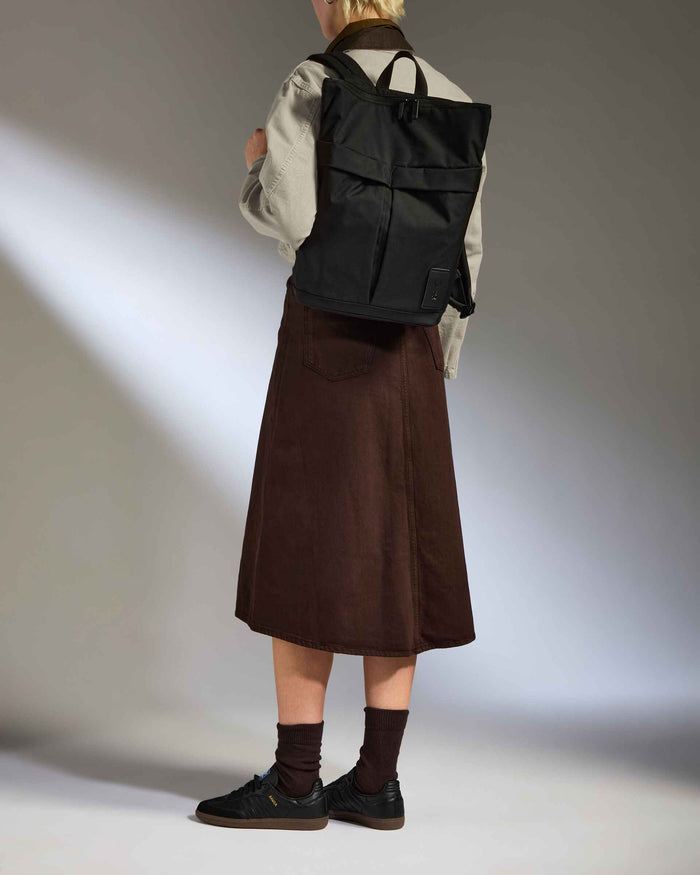 a woman wearing a skirt and a backpack