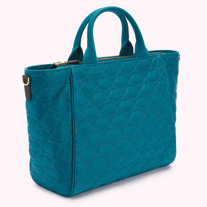 Teal quilted tote bag with top handles and zipper closure.