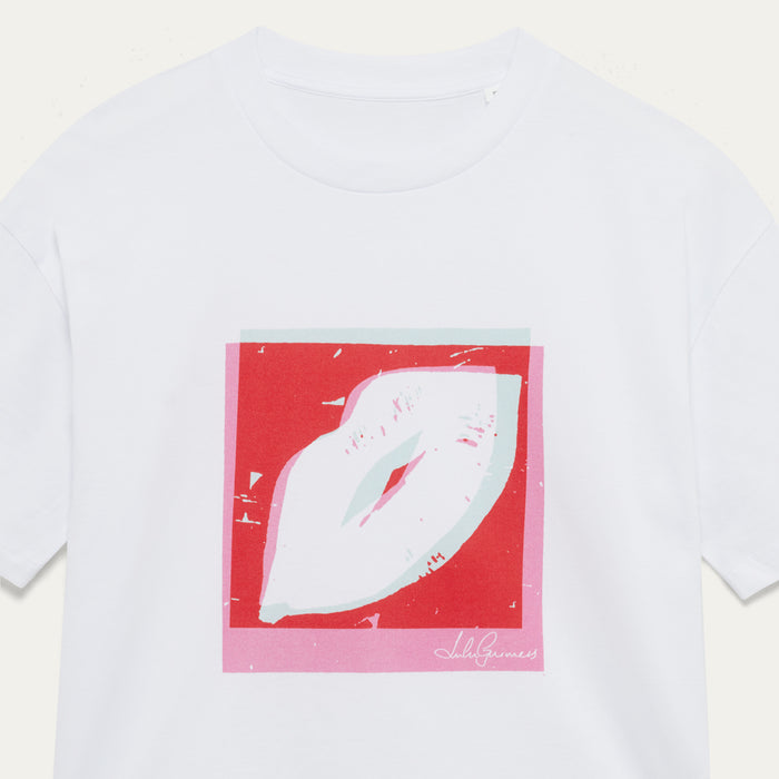White t-shirt with a red and pink pop art style lip graphic on a light beige background