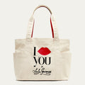 Beige tote bag with 'I Lip YOU x Lulu Guinness' and red lips design on a white background